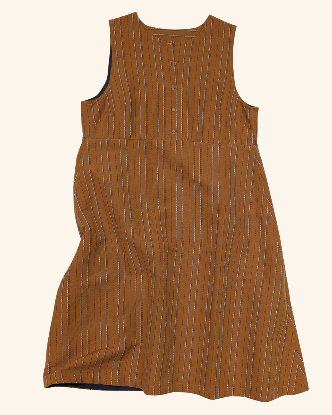 A sleeveless brown dress with thin vertical white and orange pinstripes, featuring a buttoned henley-style neckline, shown against a solid off-white background.